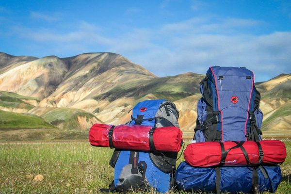 hiking backpacks on grass with mountains background