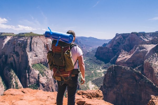 man standing on top of mountain facing mountain view