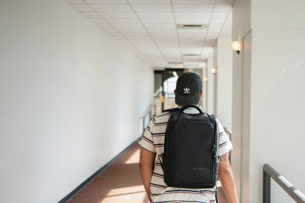 Professional carrying a work backpack through an office hallway