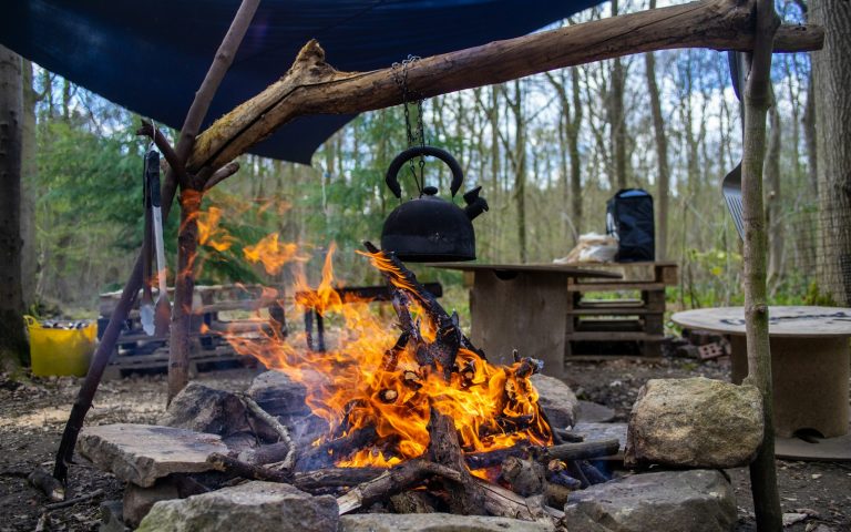 Camping kettle heating over an outdoor fire