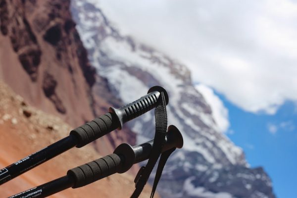 Hiking poles with a snow-capped mountain in the background.