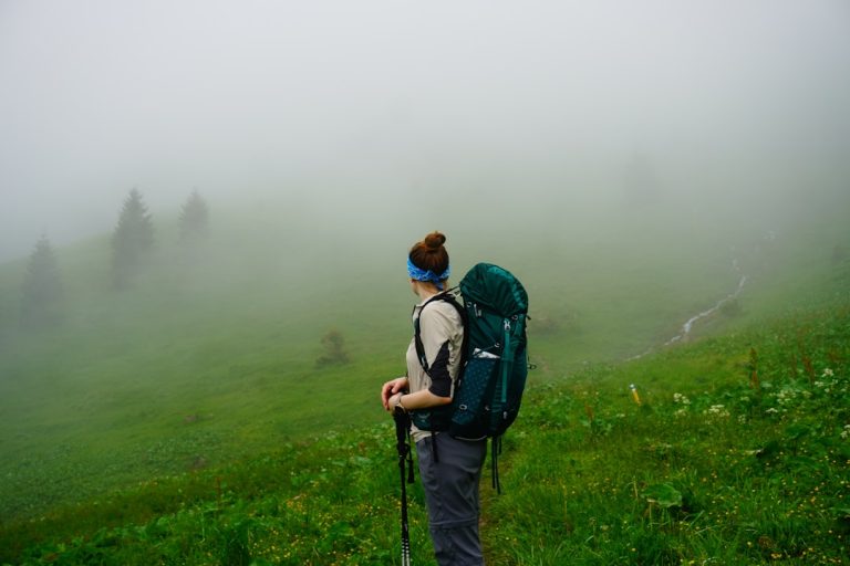 a man with a backpack walking through a field