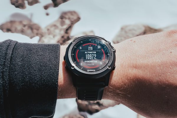 A smartwatch displays the time on a mossy surface