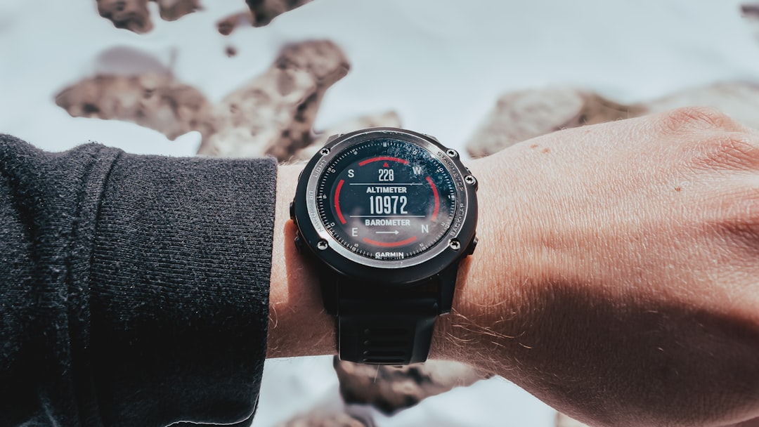 A smartwatch displays the time on a mossy surface
