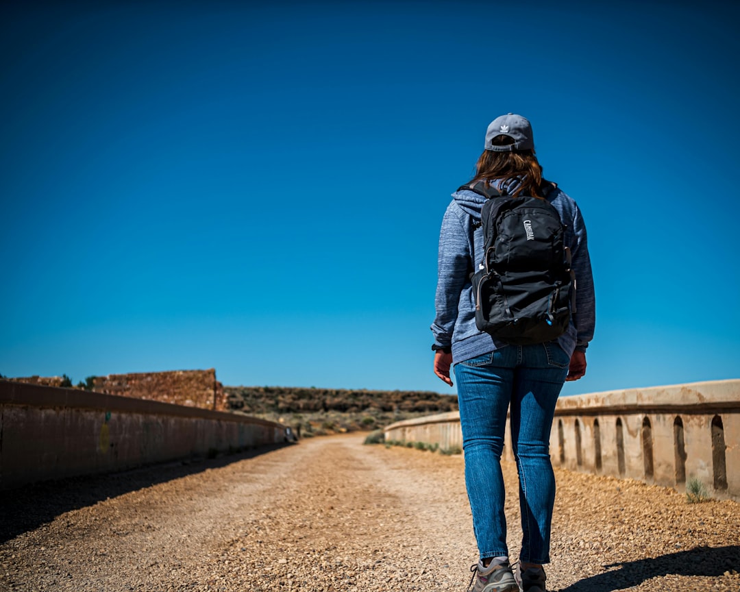 Woman with backpack walking on a dirt road