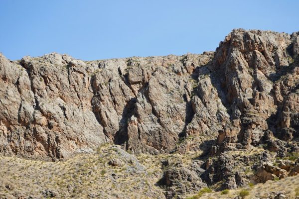 Woman rock climbing a large boulder outdoors
