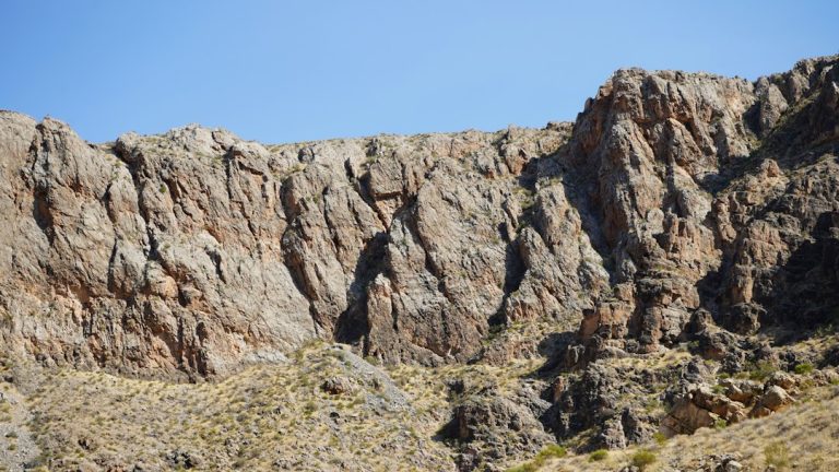 Woman rock climbing a large boulder outdoors