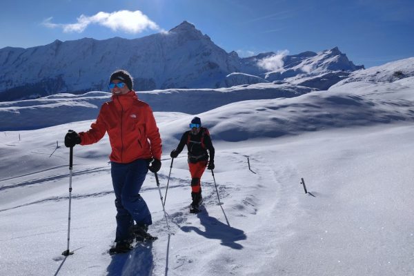 man in red jacket and black pants with black ski blades on snow covered mountain during