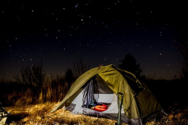 dome tent on mountain top with sun as background photo