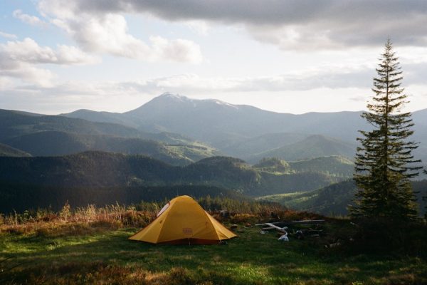 dome tent on mountain top with sun as background photo