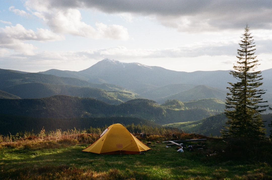 dome tent on mountain top with sun as background photo
